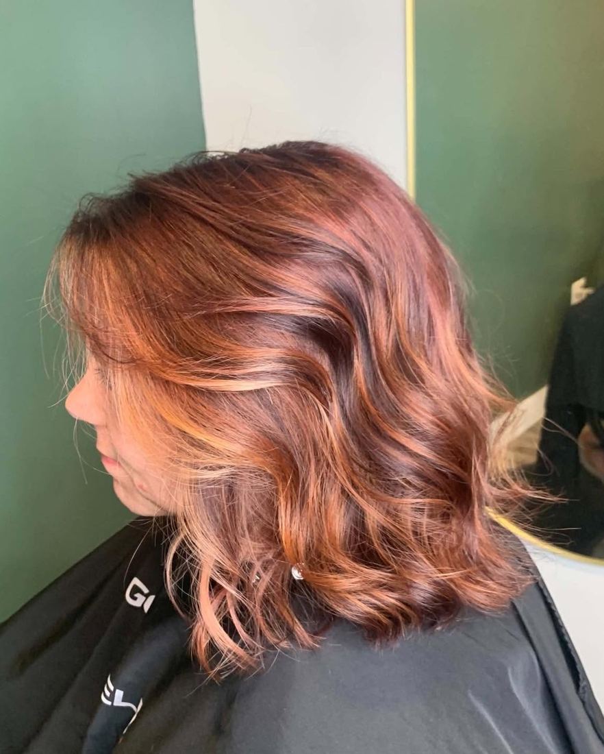 Copper red shoulder-length cut with soft waves